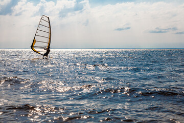 Man on a water sailing windsurfing board.