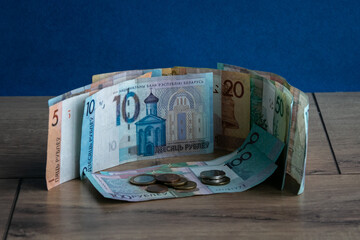 Belarusian paper money and coins on a wooden background close-up. Banknotes of the Republic of...