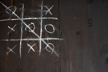 Fototapeta na wymiar doors made of old boards, damaged by worms. Tic-tac-toe game drawn with chalk