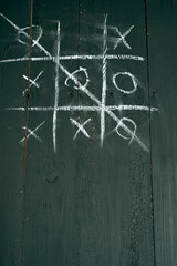 doors made of old boards, damaged by worms. Tic-tac-toe game drawn with chalk