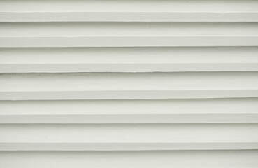 White ribbed surface background. Striped board structure. Wall with horizontal lines close-up. Building siding.