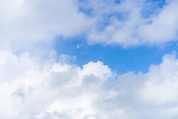 White cumulus clouds in a bright blue sky. Azure sky and open air. Clouds in the morning sunny transparent sky. Clear weather.