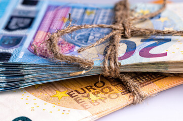 stack of euro banknotes tied with burlap string, close-up, wealth and prosperity concept
