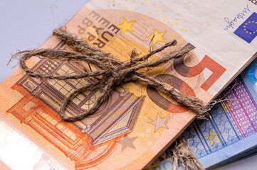 stack of euro banknotes tied with burlap string, close-up, wealth and prosperity concept