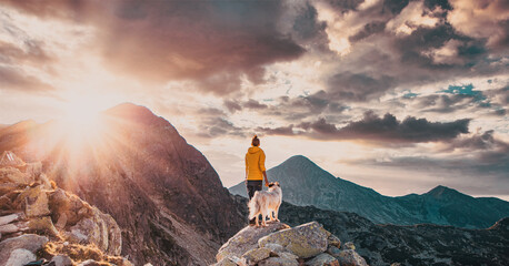 woman with white dog sitting on mountain top in summer landscape slow travel and freedom concept