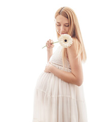 young pregnant woman in a white dress on a white background with flowers in her hands