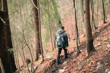 Obraz premium Carefree young trekkers in the winter vacation hiking uphill on a picturesque mountain. Tourist couple exploring the stunning Carpathians for fun recreation