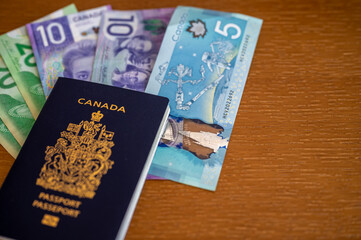 Fototapeta premium View of Canadian passport with Canadian money on brown background.