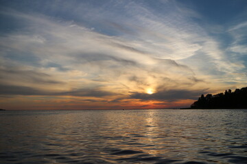 Fototapeta na wymiar picturesque sunset, bizarre clouds illuminated by the setting sun, sea view