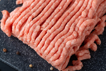 Fresh raw minced beef in a plate close up on a rustic wooden table