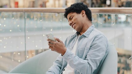 African american guy loser man playing mobile online betting game getting rejection message in phone loses reading bad news failure hitting table with fist from disappointment gesture dismissal lost