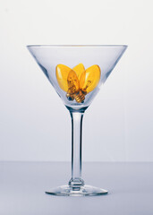 Festive yellow light bulbs in empty martini glass