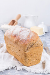 Loaf of homemade no knead sandwich bread with white cloth, vertical