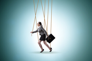 Businesswoman puppet being manipulated by ropes