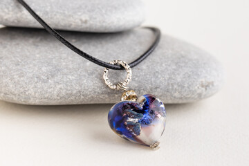 Heart pendant on gray stones.