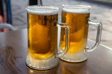 Two pint glasses with cold beer served outdoor
