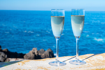 New year celebration with two glasses of champagne or Spanish cava sparkling wine and view on blue Atlantic ocean, Canary islands, winter tourists destination