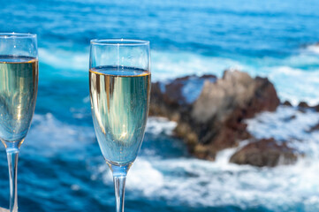 New year celebration with two glasses of champagne or Spanish cava sparkling wine and view on blue Atlantic ocean, Canary islands, winter tourists destination