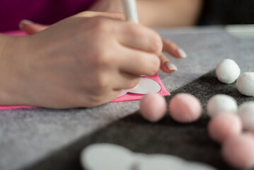 Obraz na płótnie Canvas Women's hands make a heart pattern on pink felt. Step-by-step instructions for creating hand-made products from felt. step 1.Mobile in the crib