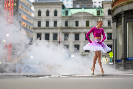 Urban Ballerina dancing in the city in pink tutu