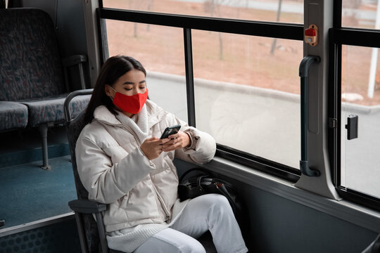 Asian woman texting message in bus