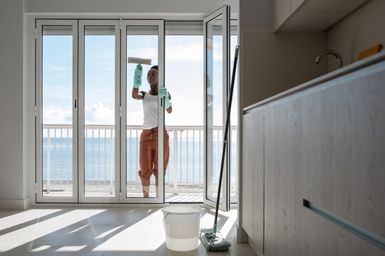 Female washing balcony window in kitchen