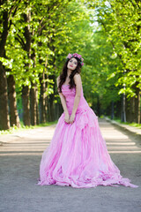 Obraz na płótnie Canvas Perfect fashionable celebrity woman in pink dress posing outdoor on summer nature background