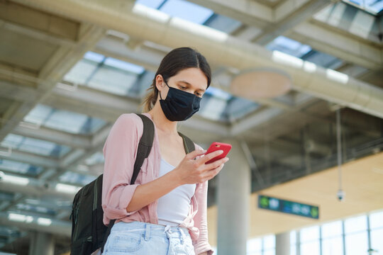 Woman wearing facial mask at the airport with backpack