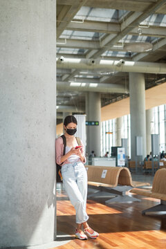 Woman wearing facial mask at the airport with backpack