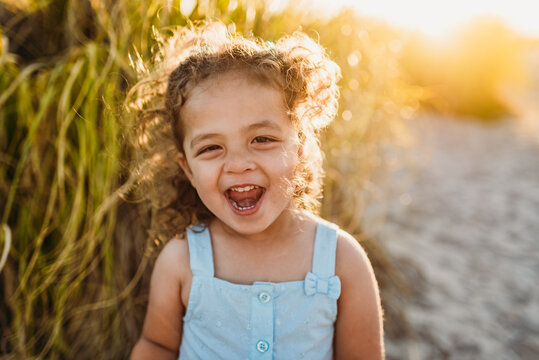 Happy young girl in front of tall sandgrass