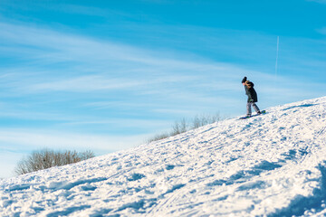 Fototapeta na wymiar A kid snowboards down a hill