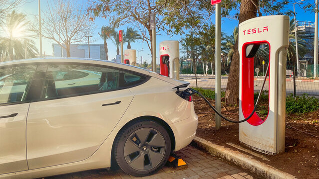 Haifa, Israel - February 6, 2022: Tesla cars while charging at Tesla supercharger Station. Tesla Charging point.