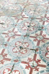 A detail of a vintage blue and white and rust colored tile floor.