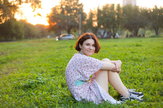 the girl is sitting in the meadow
