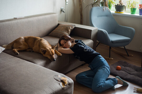 tired girl near sleeping dog
