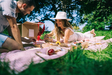 Happy couple enjoying picnic in countryside