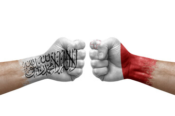 Two hands punch to each others on white background. Country flags painted fists, conflict crisis concept between afghanistan and malta