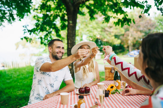 Friends with sparklers on picnic