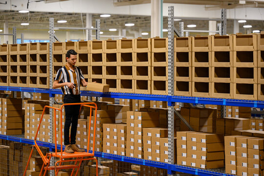 Handsome Hispanic man with laser scanner  at warehouse