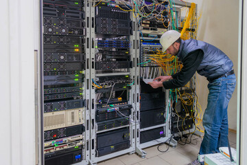 A technician works in a server room. Support for the network information infrastructure of the data...