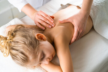 Fototapeta na wymiar a woman gives a massage to a little girl, children's massage, prevention of scoliosis, osteopathy