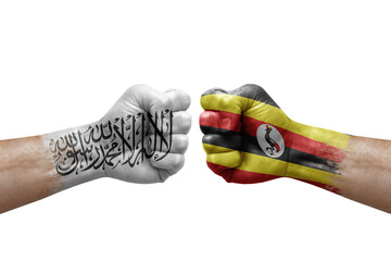 Two hands punch to each others on white background. Country flags painted fists, conflict crisis concept between afghanistan and uganda