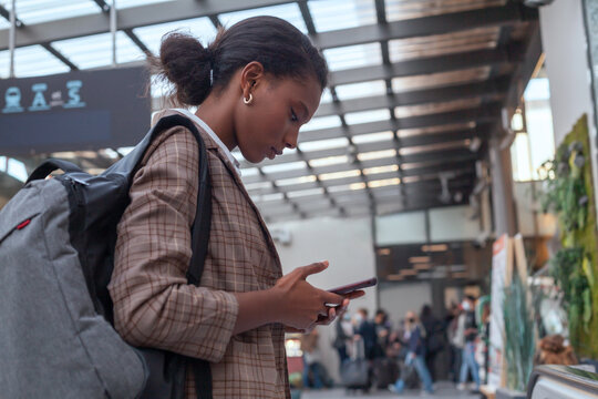 black business woman using smartphone at train station
