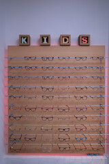 shelf with children glasses hangs in a store for glasses