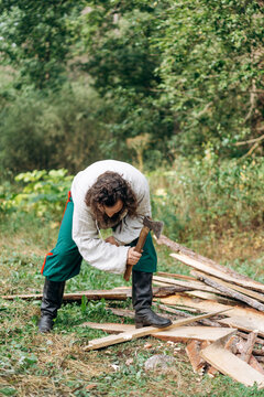 A bearded man in vintage clothing with an ax