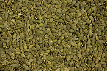 background of green pumpkin seeds, close up