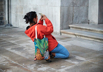 A Spanish female taking photo of some buildings
