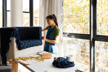 Woman upholstering armchair at home