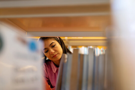 Woman choosing books at library