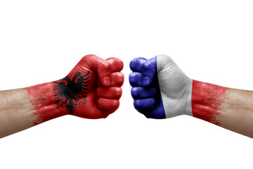 Two hands punch to each others on white background. Country flags painted fists, conflict crisis concept between albania and france